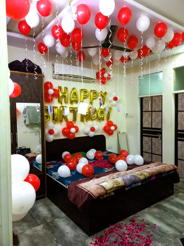 Jaipur room birthday balloon decoration with red-white theme and golden foil banner
